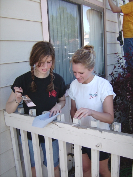 Rachelle Dietz (left) and Catherine Compton paint a balcony railing for the Boulder County Housing Authority as part of the Boulder Colorado Stake’s Colorado Cares Day project on May 12, 2007. 